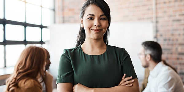 smiling woman with group and whiteboard in background