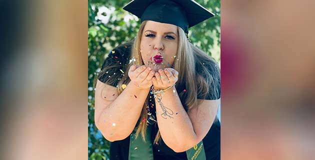 Graduate blowing confetti