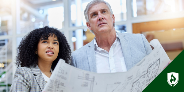 A young, Gen Z woman and an older man look at a blueprint together