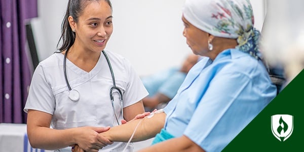 图为护士与静脉输液的病人一起工作，静脉输液代表血管通路护理